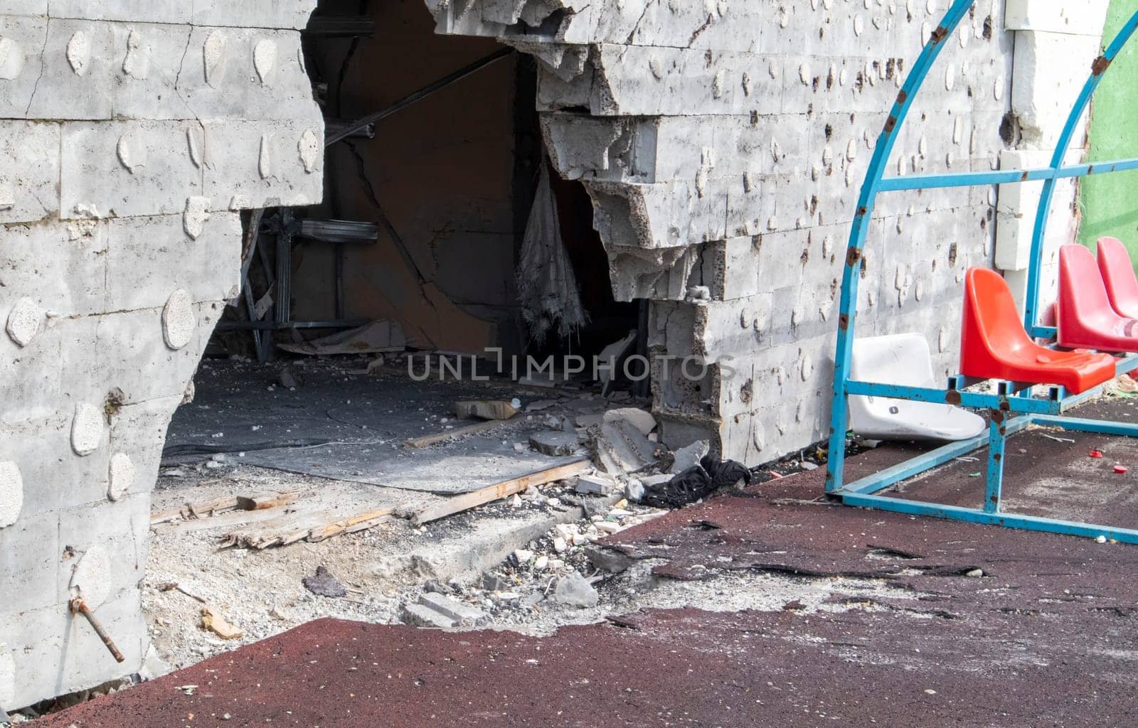 War in Ukraine. Exploded football stadium as a result of rocket attack. Broken benches for fans in the stands. Destroyed stands of the stadium. Broken fan seats