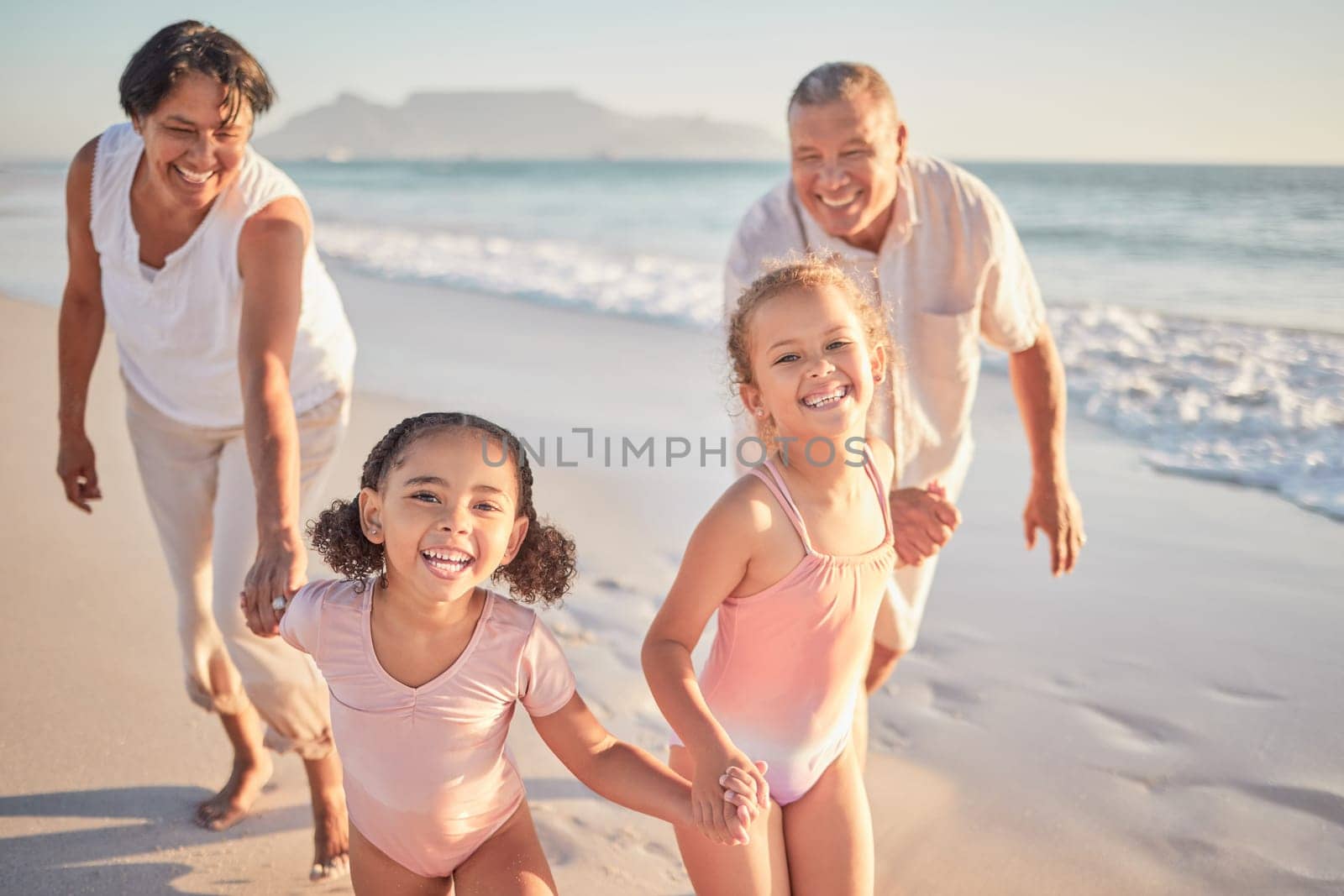 Girl, kids and happy grandparents at beach, on holiday or vacation together. Grandma, children and grandpa play by ocean, smile on family travel in summer on walk by sea in Cape Town, South Africa by YuriArcurs