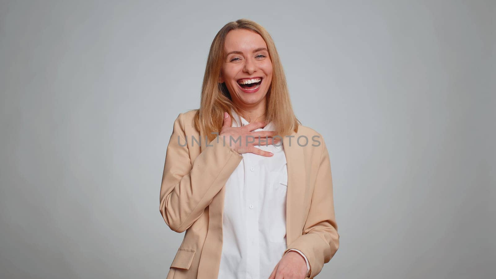 Amused office secretary woman looking to camera, laughing out loud, taunting making fun of ridiculous appearance, funny joke anecdote. Business girl isolated alone on gray studio background