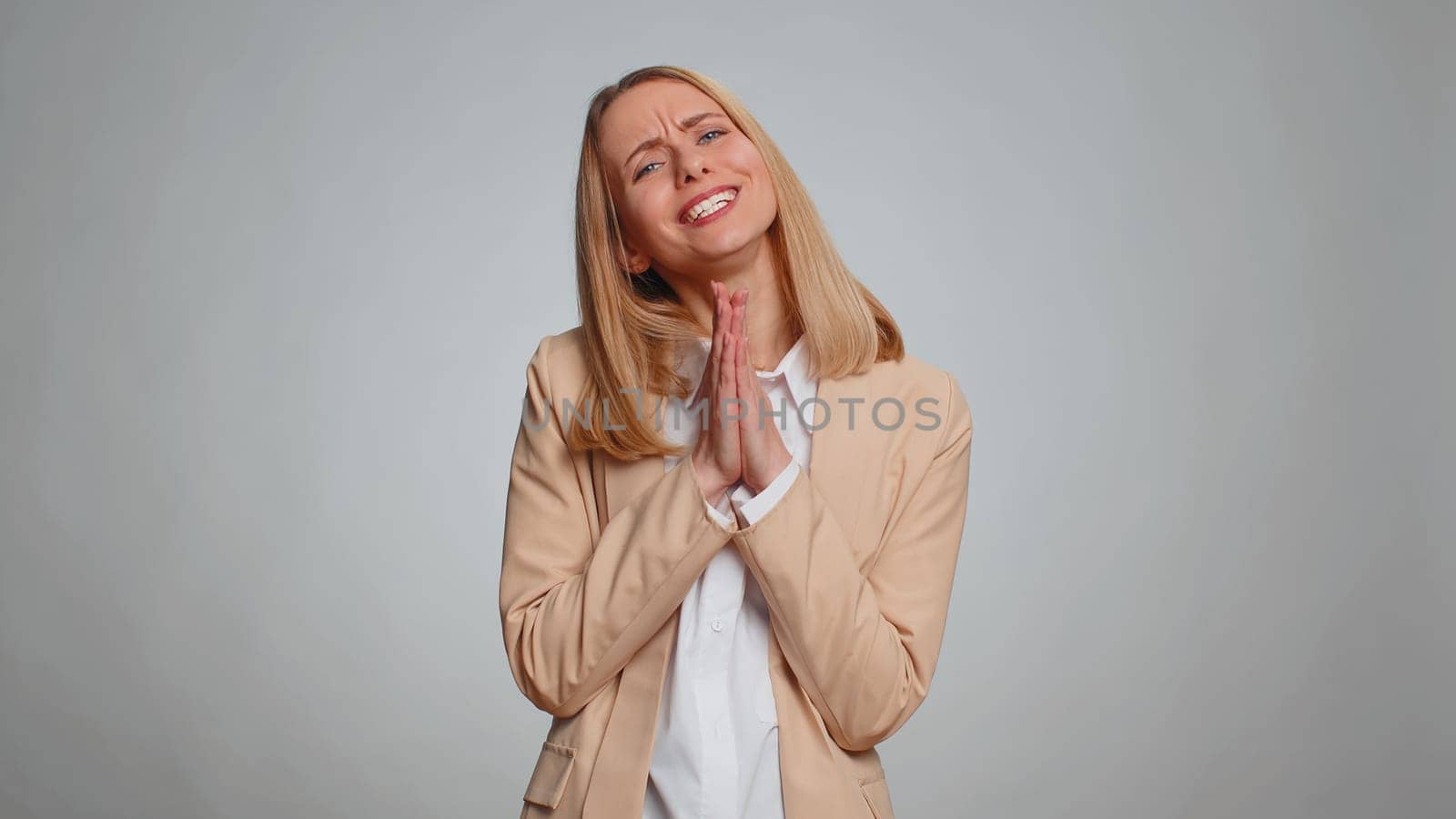 Please, God help, forgive me. Woman freelancer praying, looking upward and making wish, asking with hopeful imploring expression, begging apology. Business girl isolated on gray studio background