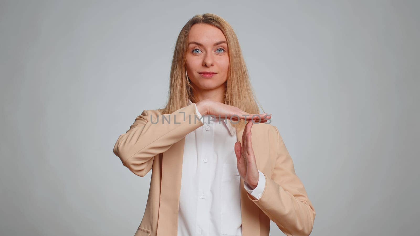 Portrait of tired serious upset businesswoman showing time out gesture, limit or stop sign, no pressure, i need more time. Female girl in formal suit. Pretty woman isolated on gray studio background