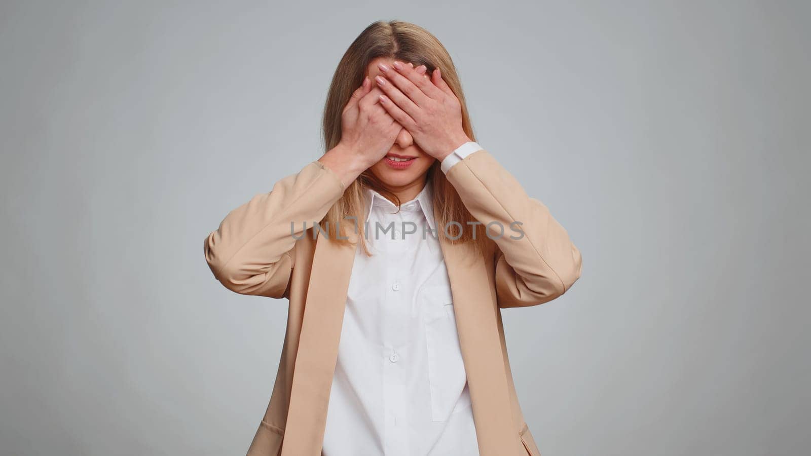 Dont want to look at this, awful. Afraid business woman closing eyes with hand showing stop gesture, confused shy scared to watch. Adult girl isolated on gray studio background. People lifestyles