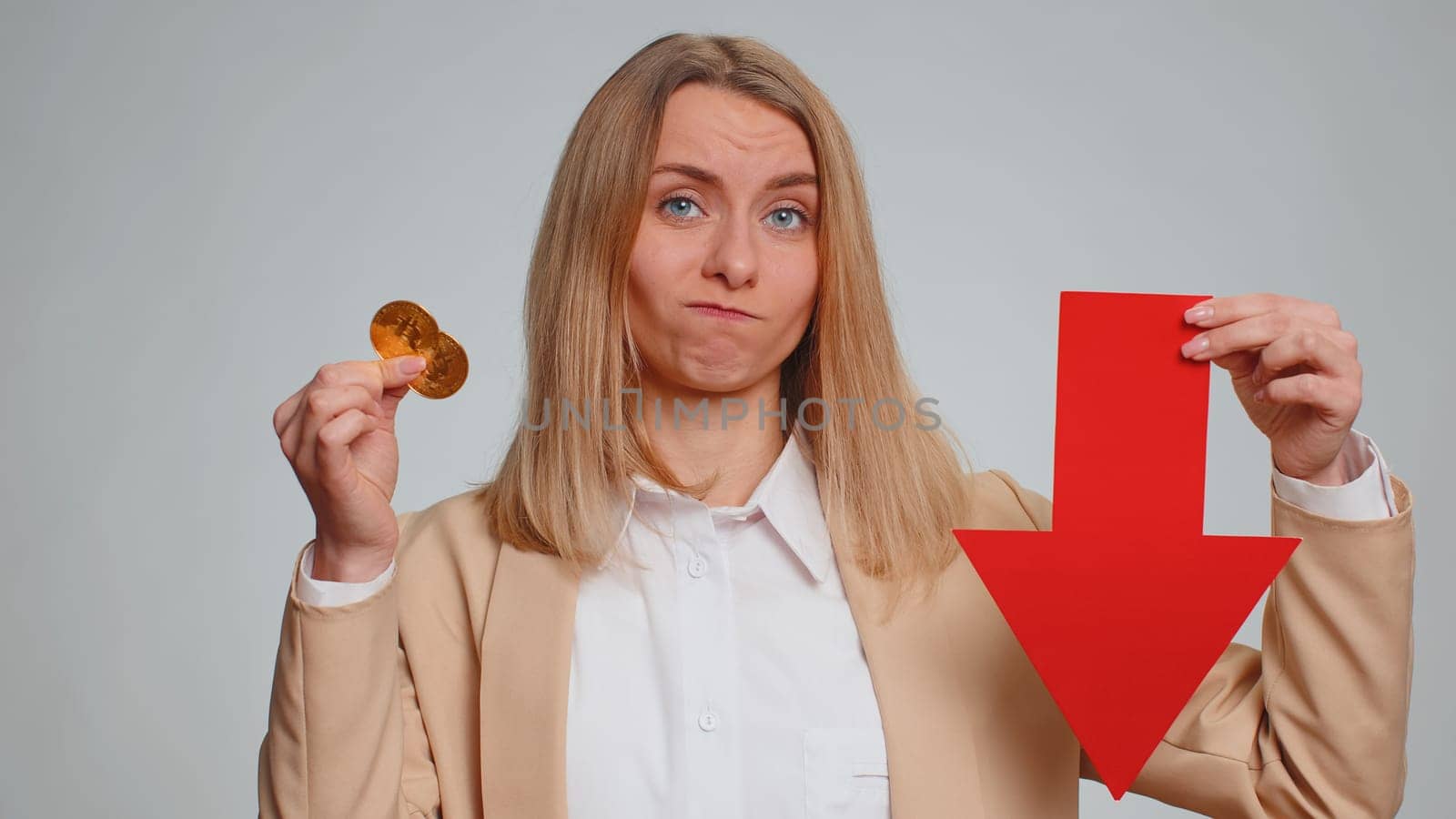 Business woman showing golden bitcoins indicating red arrow banner down sign decrease of exchange rate. Unsuccessful bankruptcy fall of stock cryptocurrency market investment mining BTC technology