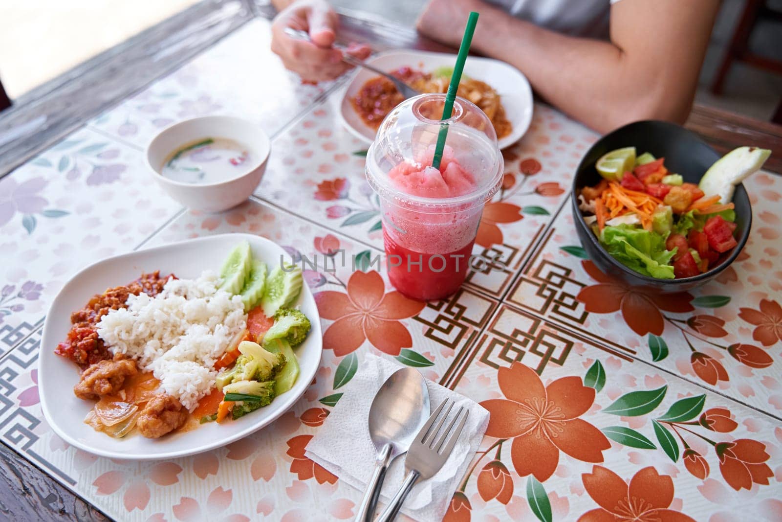 Delicious Thai Cuisine: Plates and People Dining at a Local Cafe.