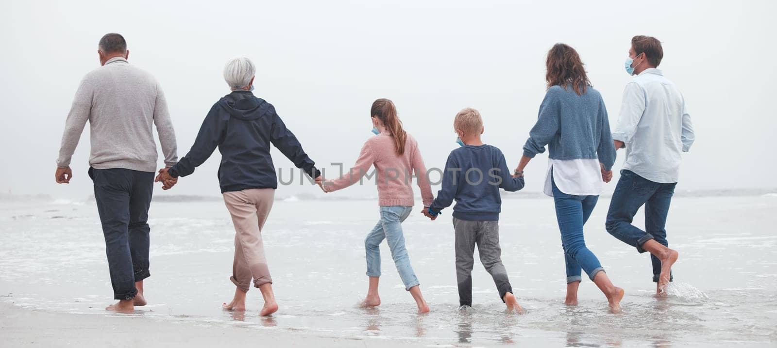Big family, holding hands and walking on beach for vacation or quality bonding time together in nature. Hand of parents, grandparents and kids enjoying travel, freedom and family fun in ocean water by YuriArcurs