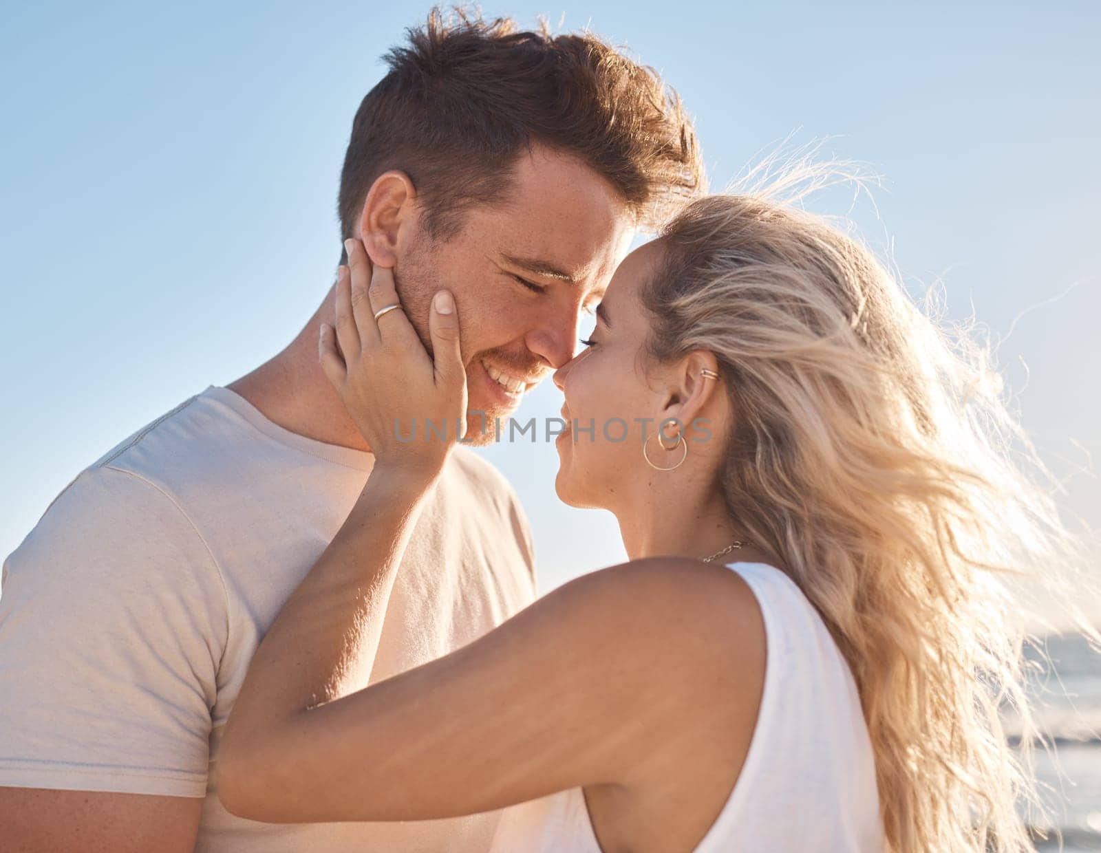 Love, couple and beach holiday, vacation or summer date and honeymoon outdoors. Affection, romance and smile of man and woman ready for kiss, having fun and enjoying quality time together at seashore by YuriArcurs