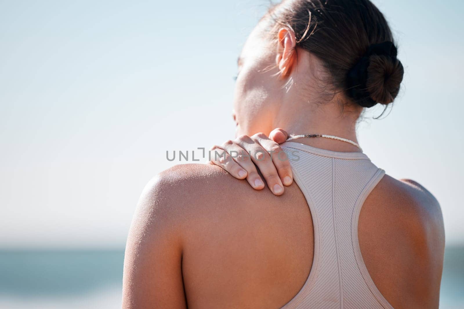 Tired, shoulder pain and fitness with woman at beach with mockup for yoga, workout and training. Burnout, injury and physical therapy with girl in city park for health, sport and pilates goals by YuriArcurs