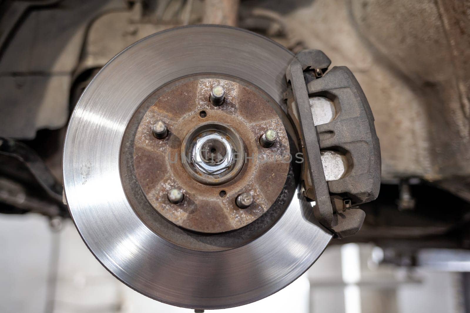 Disc brake of the vehicle for repair, in process of tire replacement by AnatoliiFoto