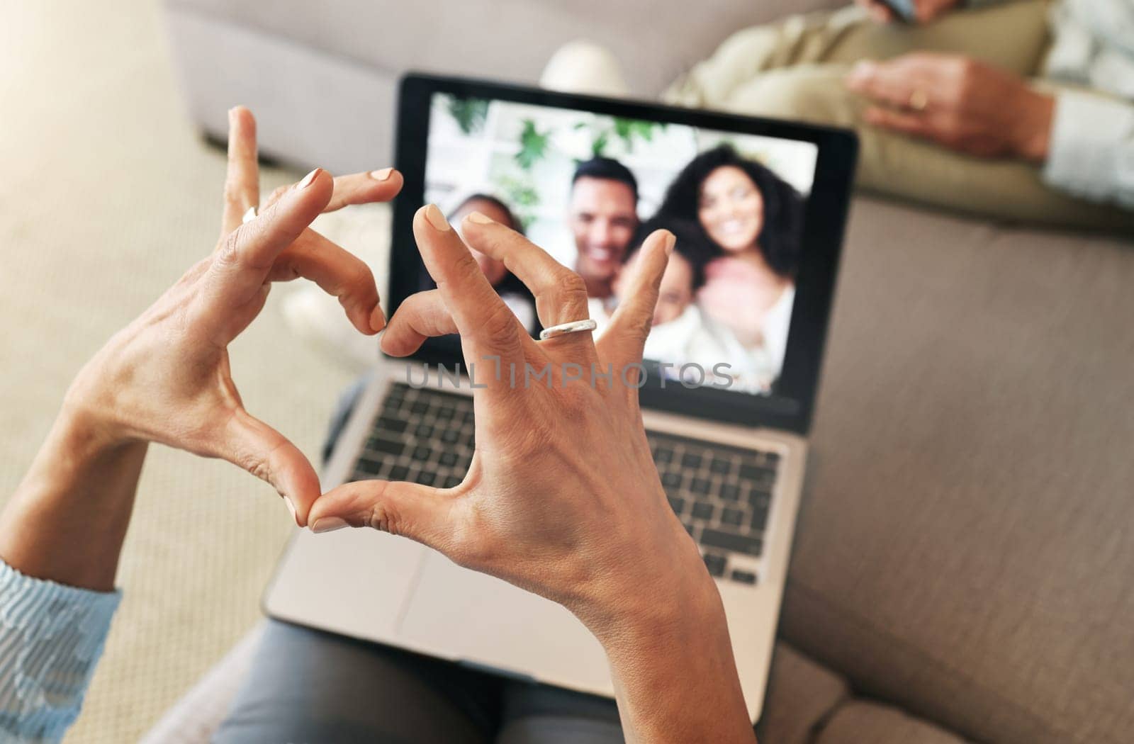 Hand heart, video call and love with laptop, family and communication with emoji, connection and bonding. Hands, person relax at home and happiness with care, connectivity with virtual chat in lounge.