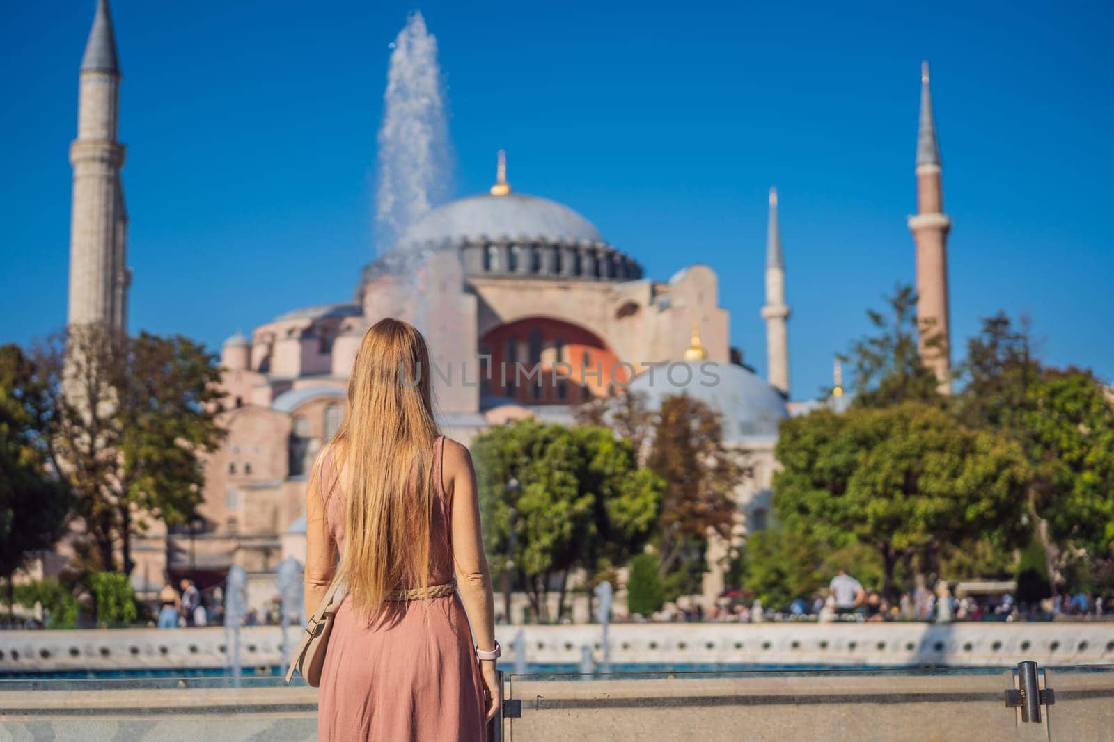 Woman enjoy beautiful view on Hagia Sophia Cathedral, famous islamic Landmark mosque, Travel to Istanbul, Turkey. Sunny day architecture and Hagia Sophia Museum, in Eminonu, istanbul, Turkey. Turkiye.