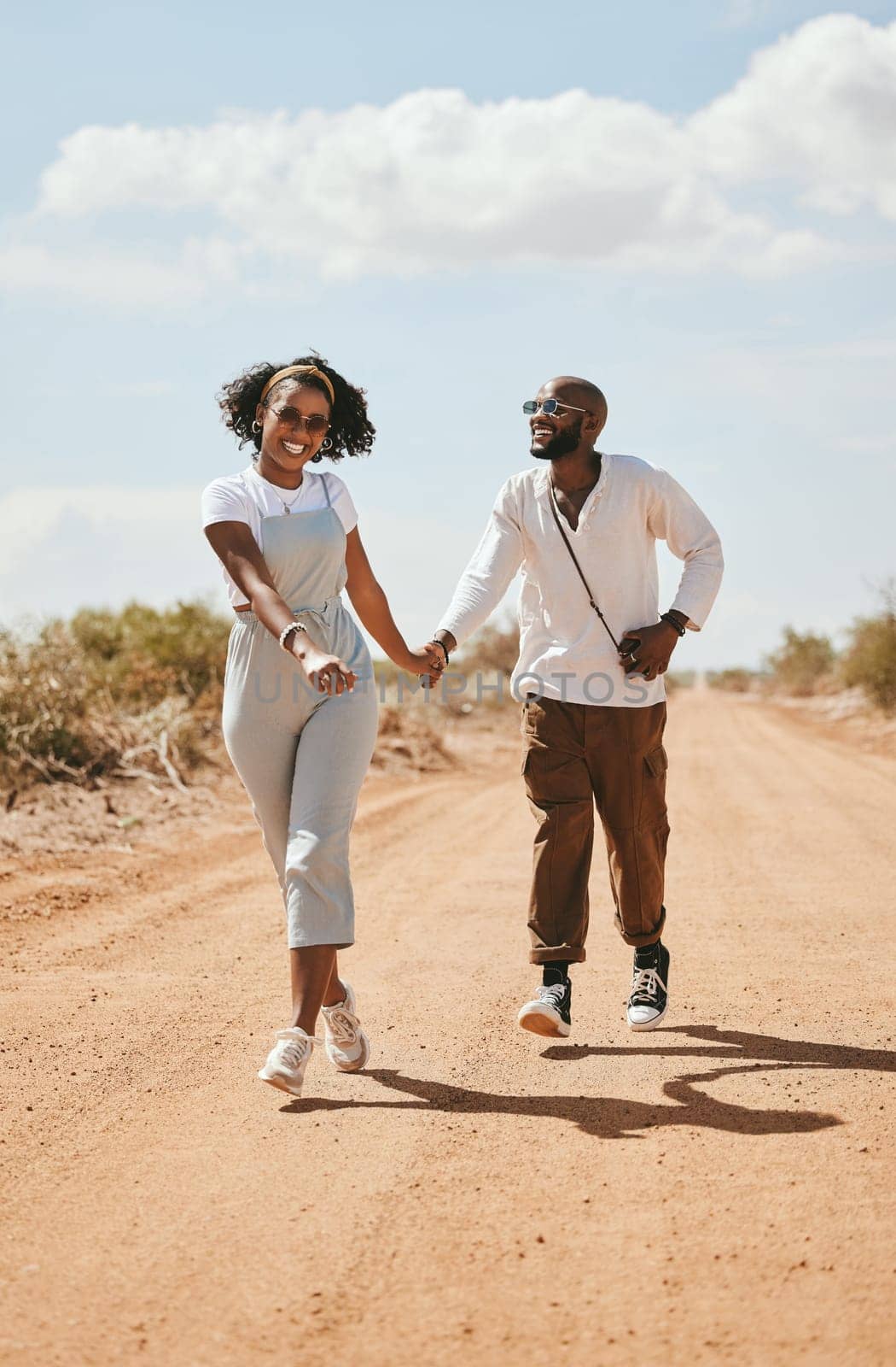 Black couple on road trip, happy people walking on vacation and Los Angeles festival travel. Summer holiday, trendy fashion lifestyle and love happiness on happy outdoor desert adventure together.