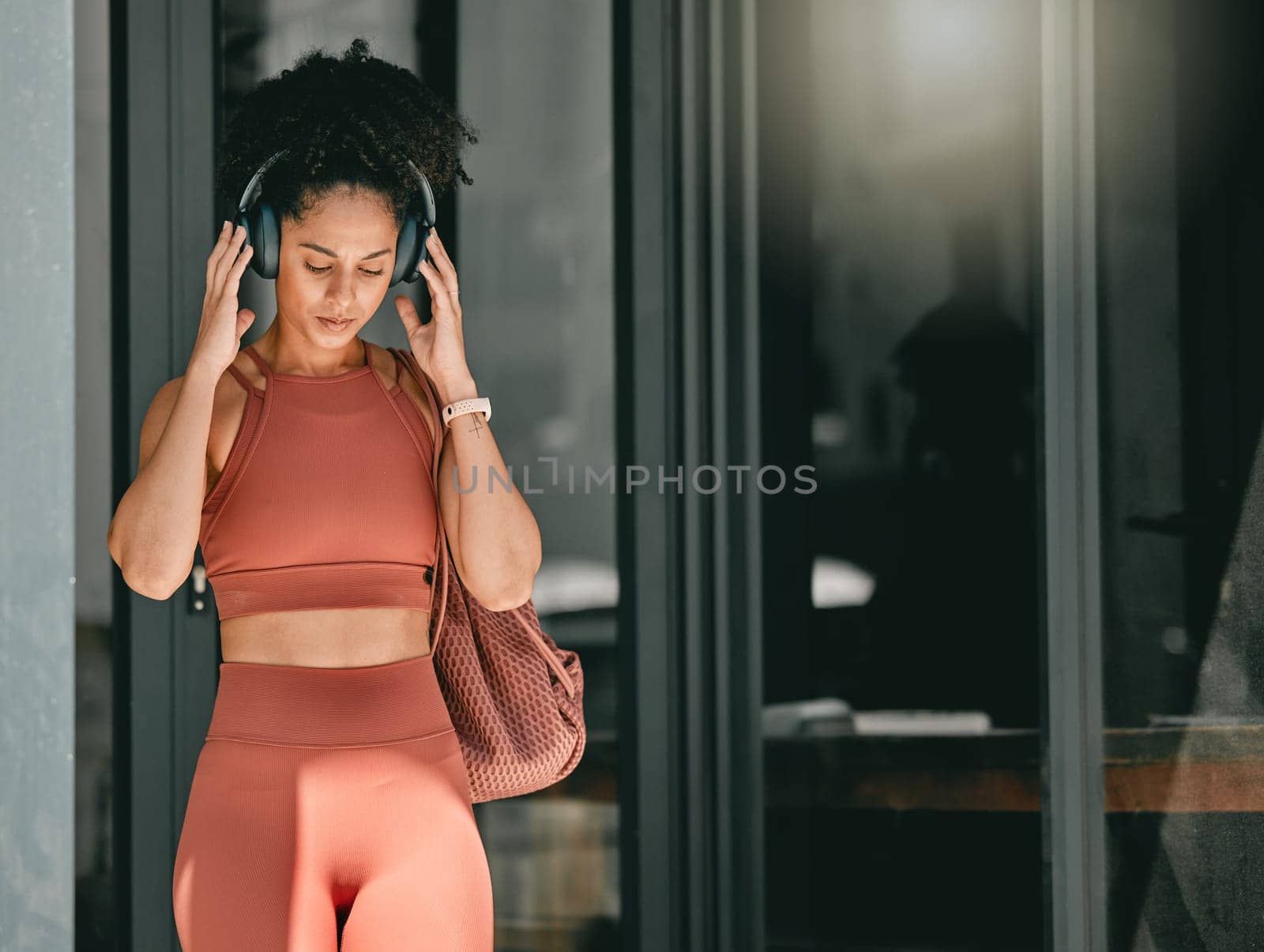 Fitness, walking and black woman listen to music, relax podcast or radio for calm, stress relief or wellness mockup. Headphones, leaving gym and mock up girl on travel after training workout exercise by YuriArcurs