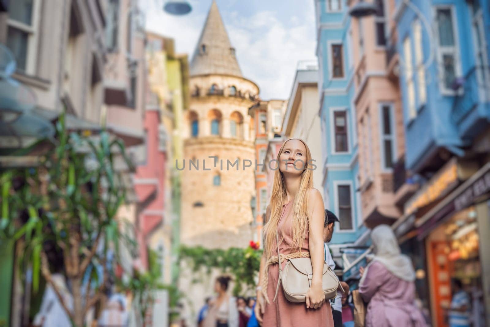 Portrait of beautiful woman tourist with view of Galata tower in Beyoglu, Istanbul, Turkey. Turkiye.