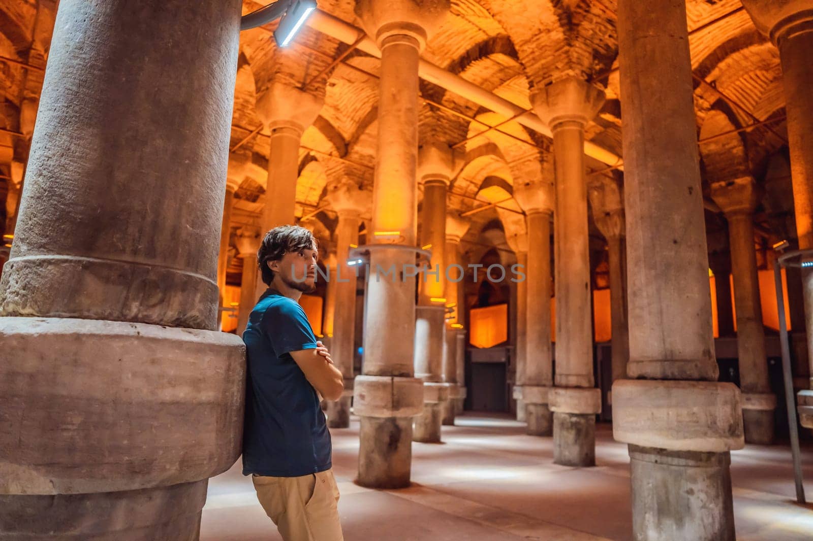 Man tourist enjoying Beautiful cistern in Istanbul. Cistern - underground water reservoir build in 6th century, Istanbul, Turkey, Turkiye.