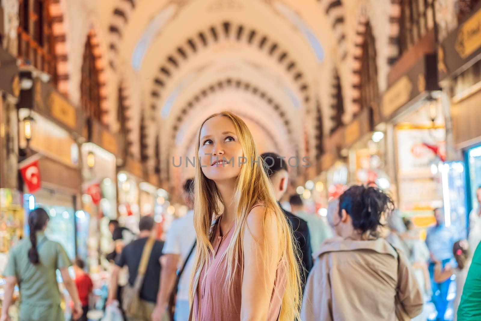 A tourist woman walks among the countless shops at the Grand Bazaar and Egyptian Bazaar in Istanbul. Shopping and travel in Turkey concept. Istanbul historical Egyptian Bazaar. Misir Carsisi, spice market. Turkiye.