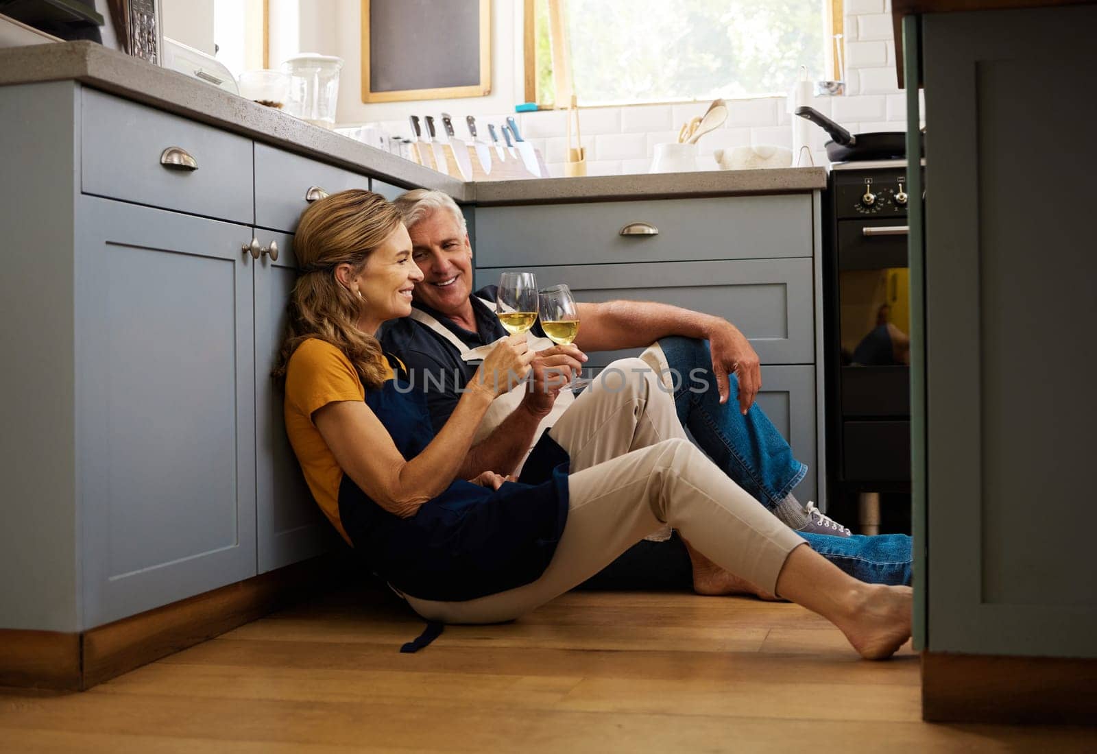 Love, senior couple and on kitchen floor, together and bonding while speaking, talking and with wine. Romantic, retirement or elderly man and woman being loving, romance and anniversary or discussion.