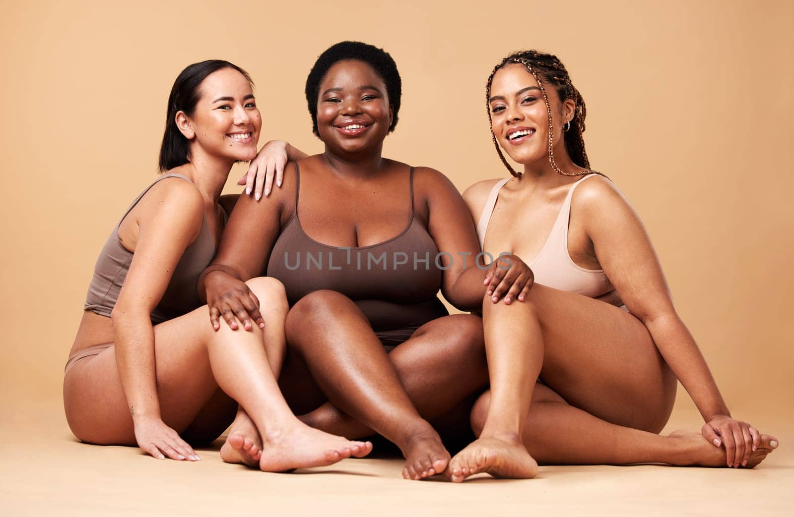 Diversity, women friends and body portrait with skin glow group together for inclusion, beauty and power. Underwear model people on beige background with a smile, pride and motivation for self love.