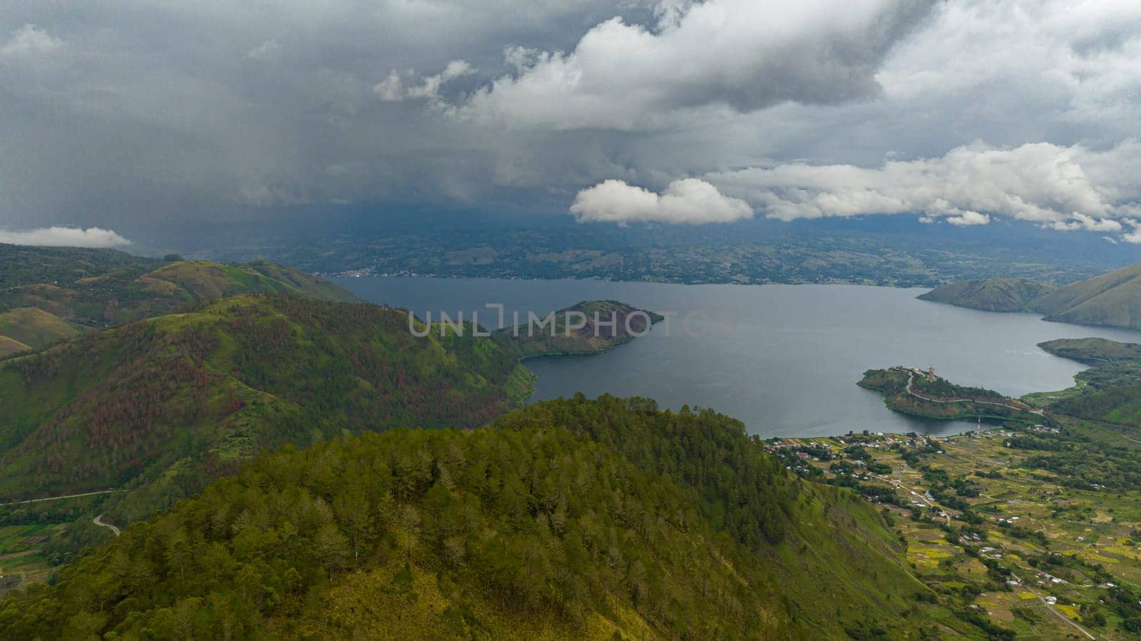 Aerial drone of Lake Toba and Samosir island. among the mountains with tropical vegetation. Sumatra, Indonesia.