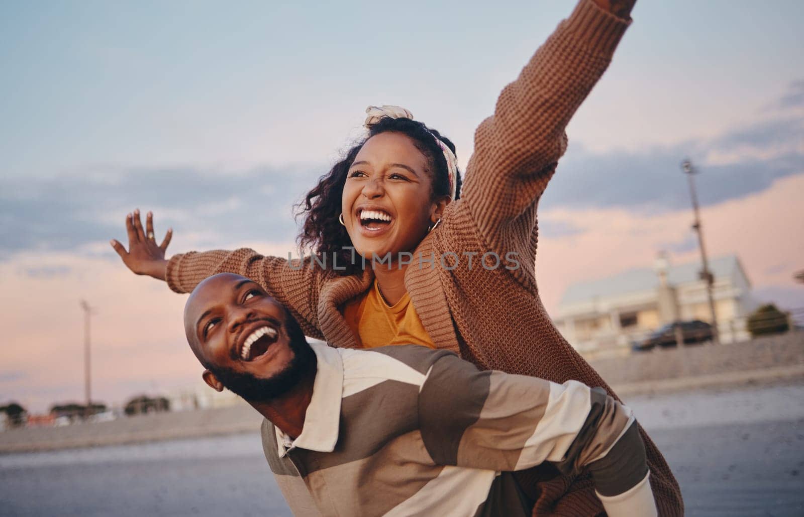 Freedom, love and happy with couple and piggy back ride together on outdoor date for support, sunset or lifestyle vacation. Smile, summer and airplane with man and woman on holiday for relax or faith by YuriArcurs