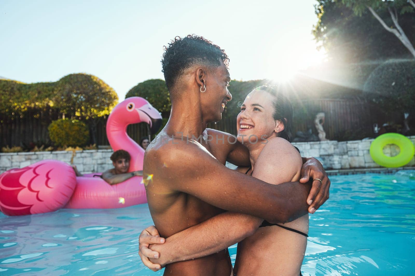 Pool party, love and couple hug, having fun and bonding together. Swimming, romance diversity and man and woman hugging, cuddle or laugh at funny joke in water at summer event or new year celebration by YuriArcurs