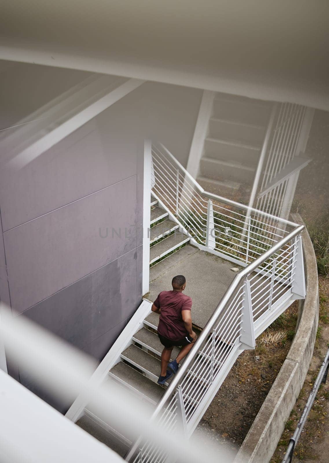 Running, fitness and top view of black man on stairs for health, wellness and exercise. Sports, training and male runner jog, exercising or cardio workout on steps outdoors for strength and endurance.