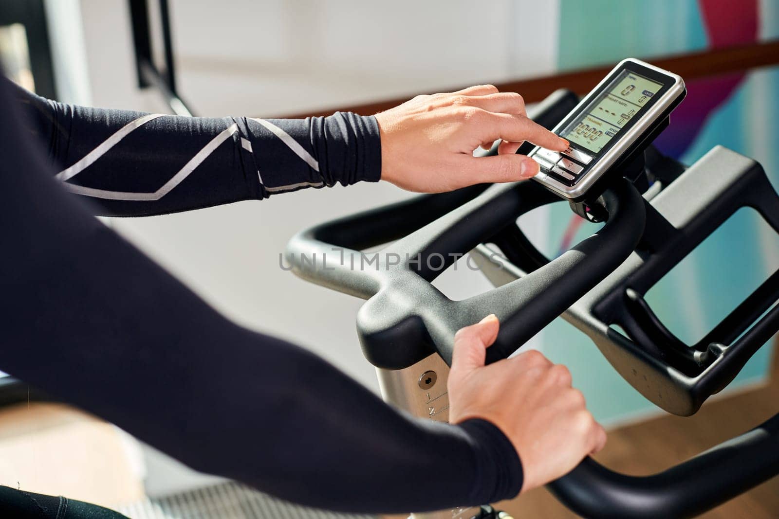 Strong female hand on a stationary bike in the gym