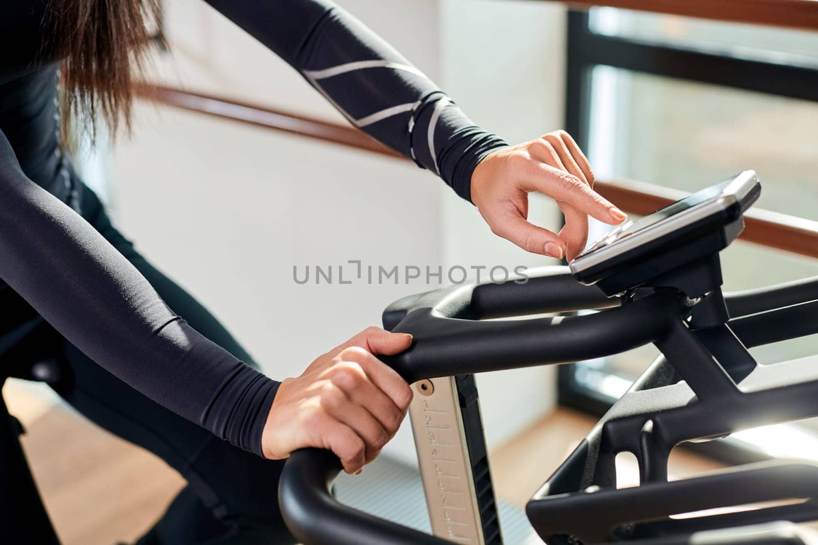 Strong female hand on a stationary bike in the gym