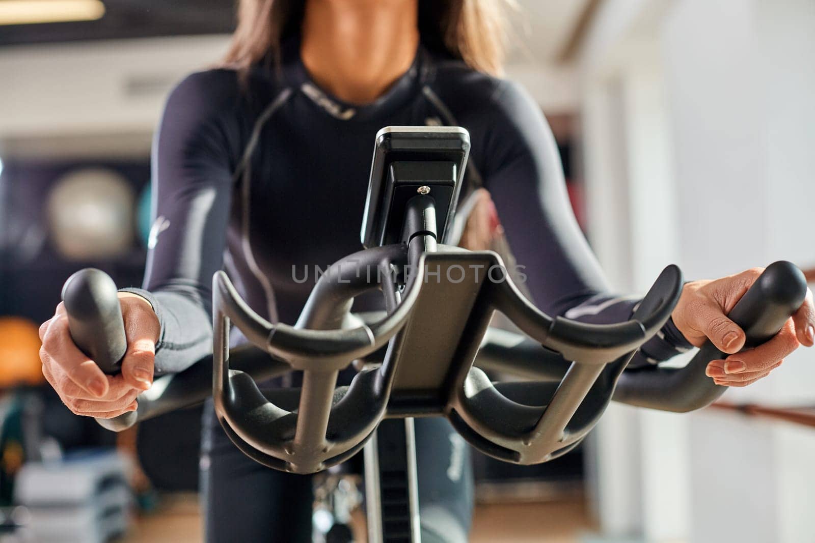 Strong female hand on a stationary bike in the gym