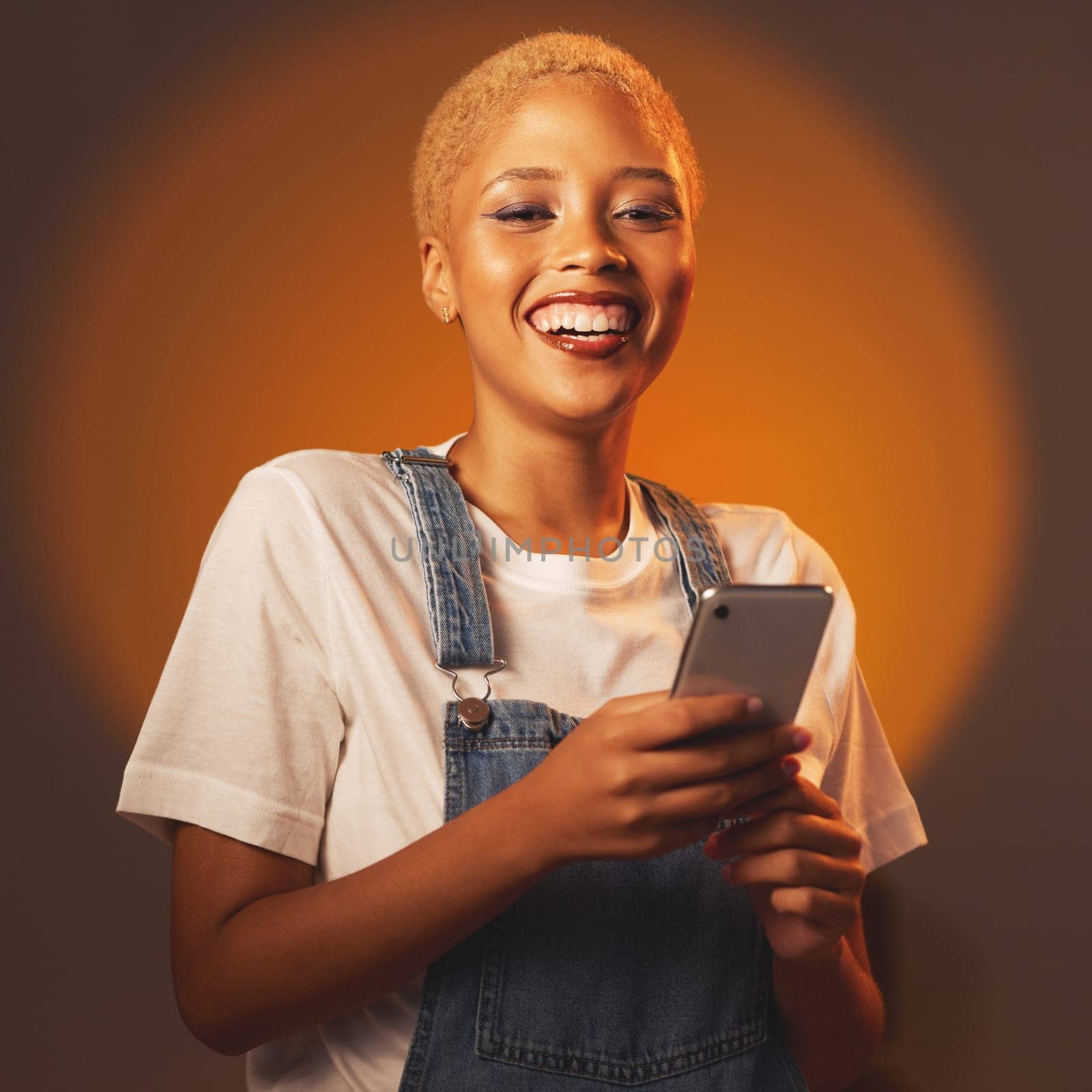 Portrait of black woman, smile and phone, typing message or email and browsing social media isolated in studio. Internet, connection and gen z fashion, happy influencer girl with smartphone in hands. by YuriArcurs