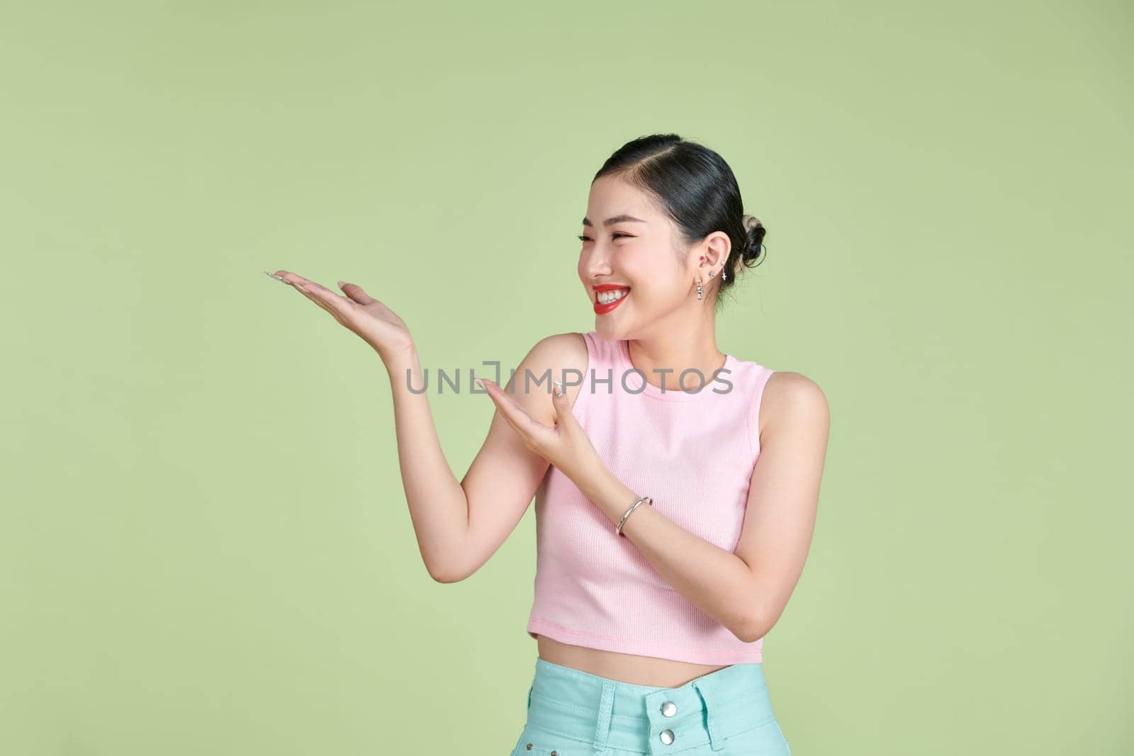 Smiling woman showing open hand palm with copy space for product or text by makidotvn