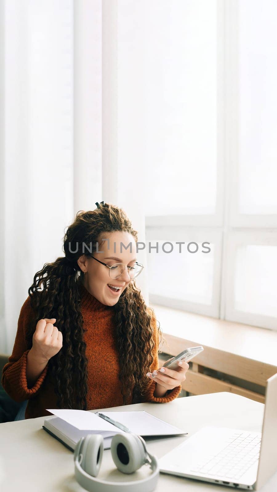Young happy lucky woman student feeling excited winner holding cellphone using mobile phone winning online, receiving great news or sms offers on a smartphone, getting a new job celebrating success