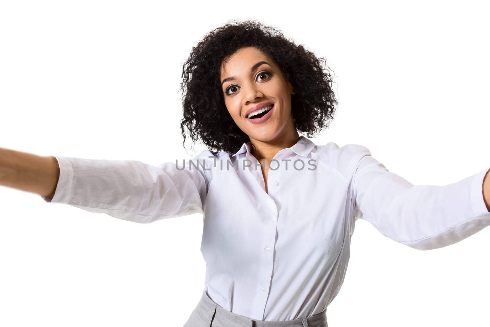 Young beautiful African American woman makes self against the white background in studio by nazarovsergey