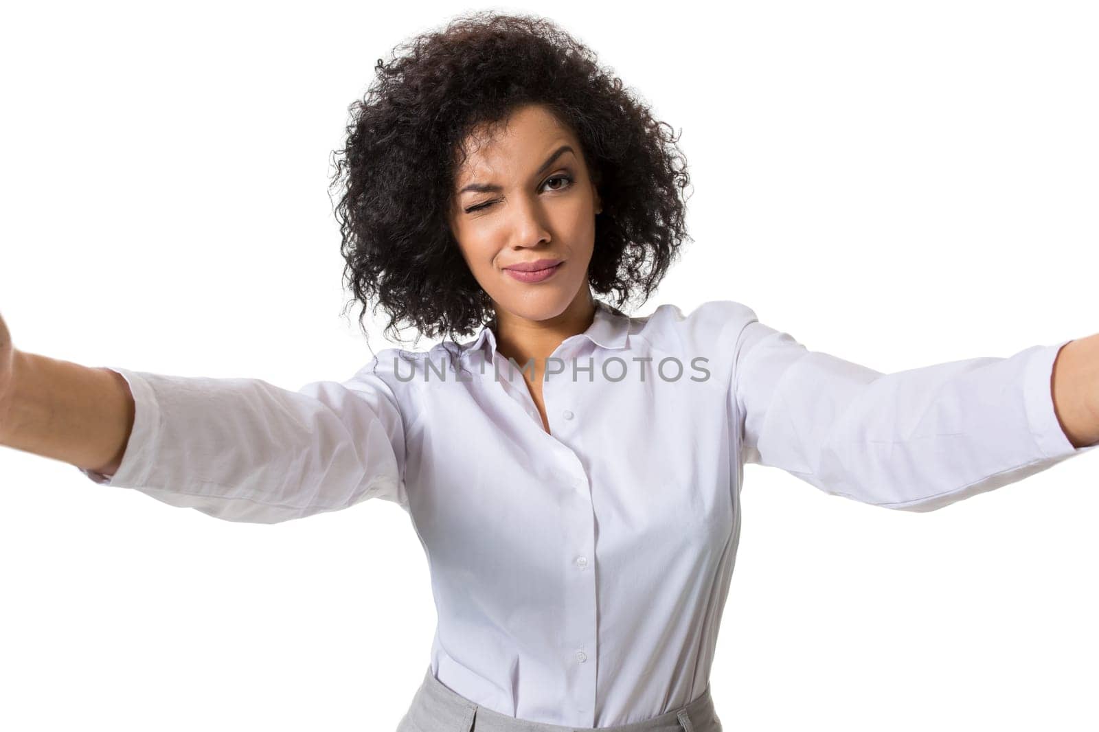 Young beautiful African American woman makes self against the white background in studio by nazarovsergey