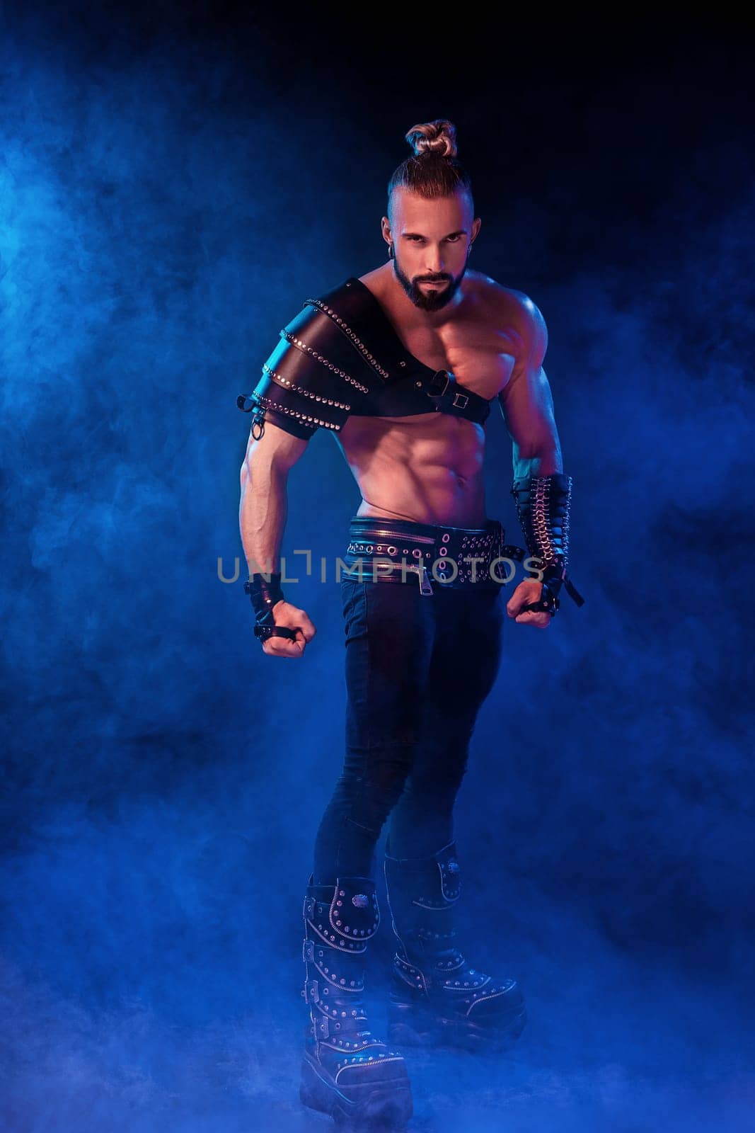 Handsome young sexy man with beautiful muscular chest in interesting costume on the scene. The Stripper man. Show time