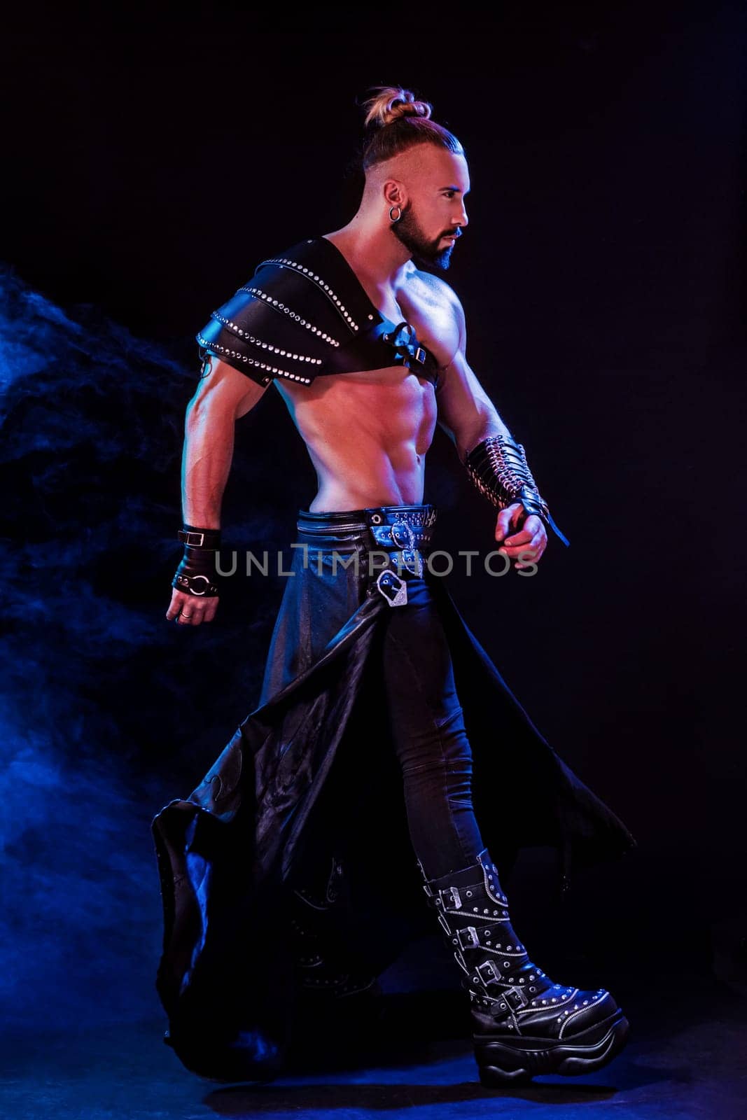 Handsome young sexy man with beautiful muscular chest in interesting costume on the scene. The Stripper man. Show time