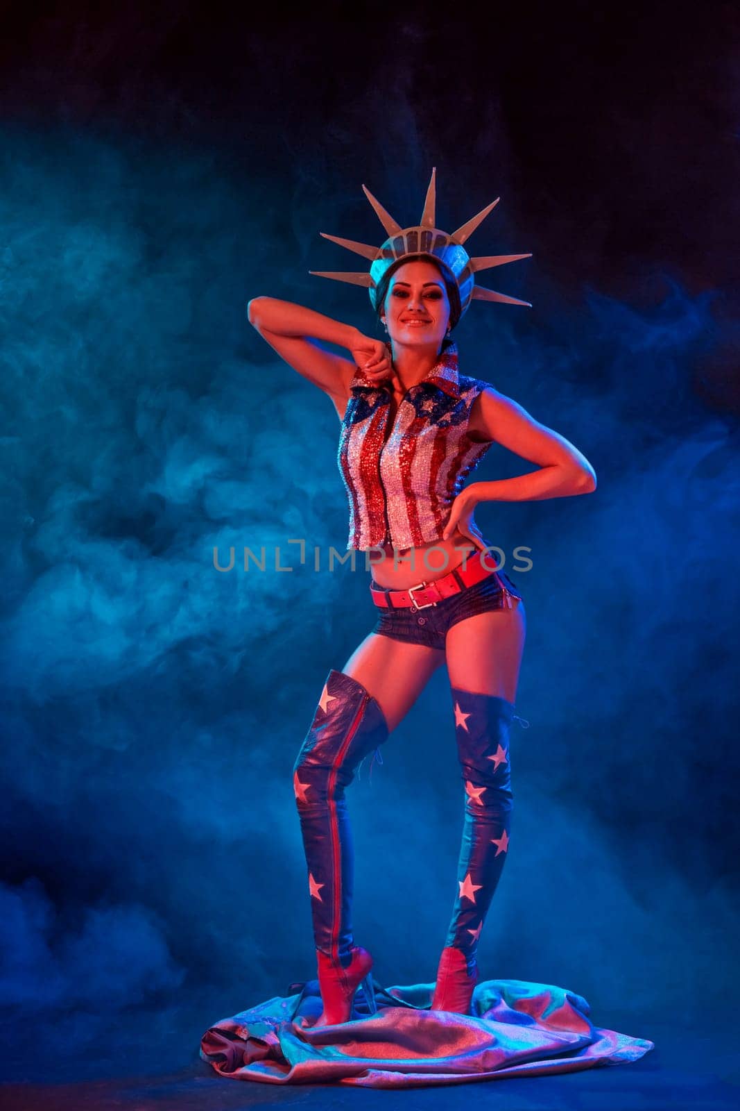 Young woman in stage costume of striptease dancer posing. Sexy woman in a statue of America costume