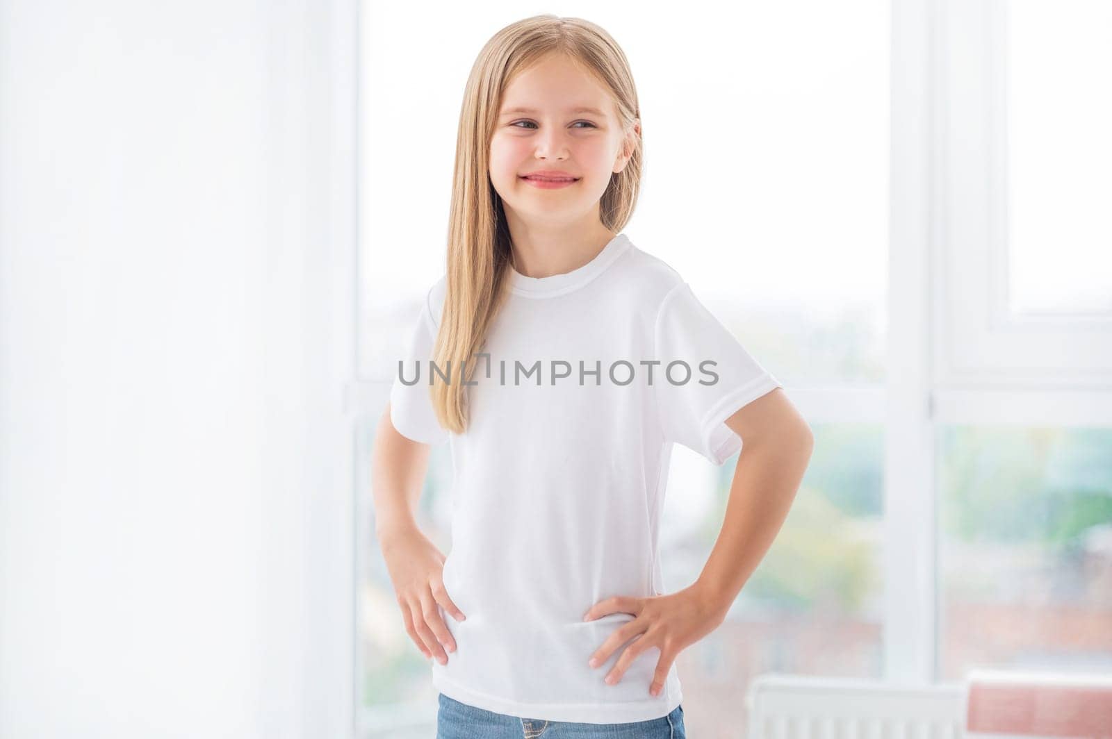Cute Smiling little girl in white t shirt in room