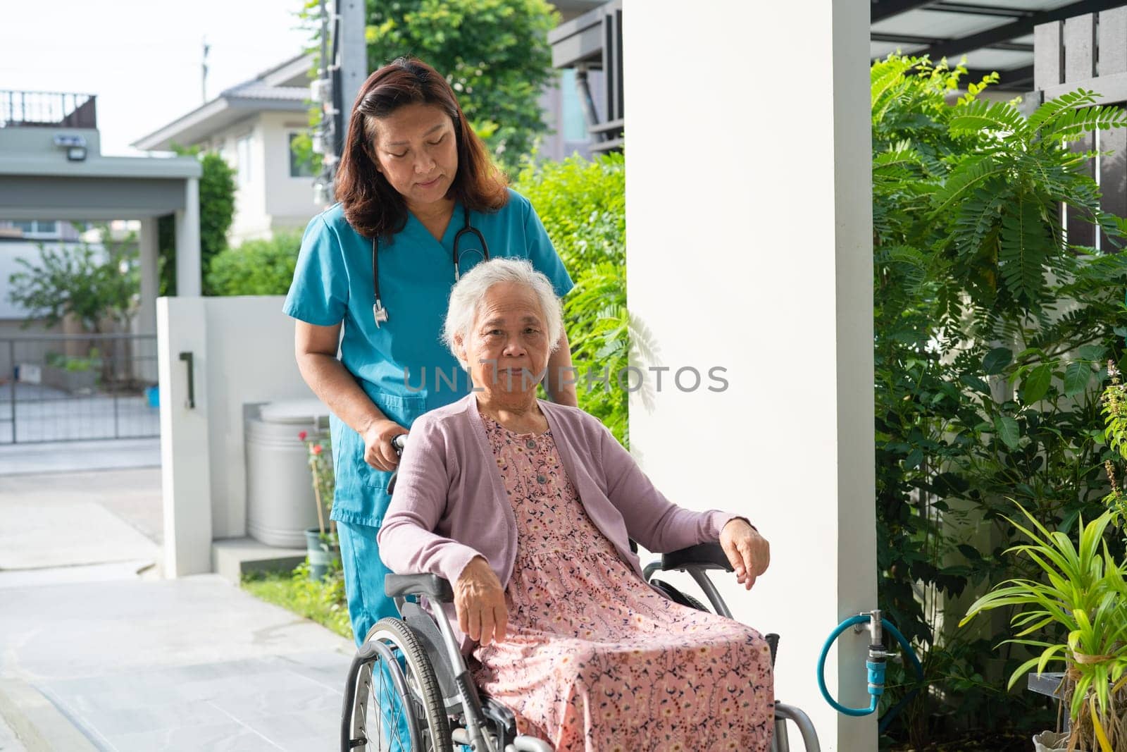 Caregiver help and care Asian senior woman patient sitting on wheelchair to ramp in hospital, healthy strong medical concept. by pamai