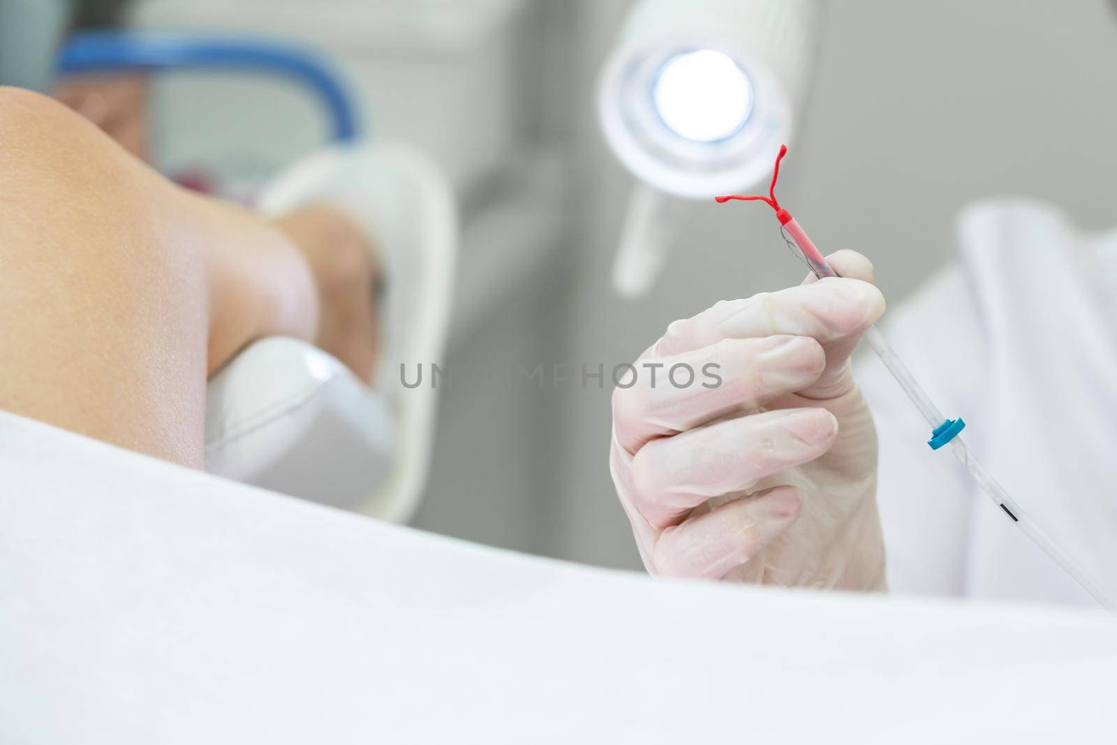 Gynecologist holding an IUD birth control device before using it for patient by Mariakray