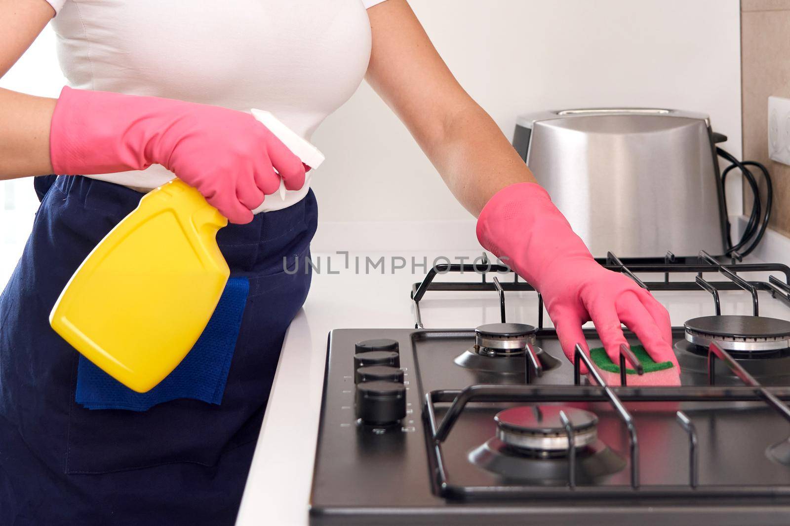 Cleaning a gas stove with kitchen utensils, household concepts, or hygiene and cleaning