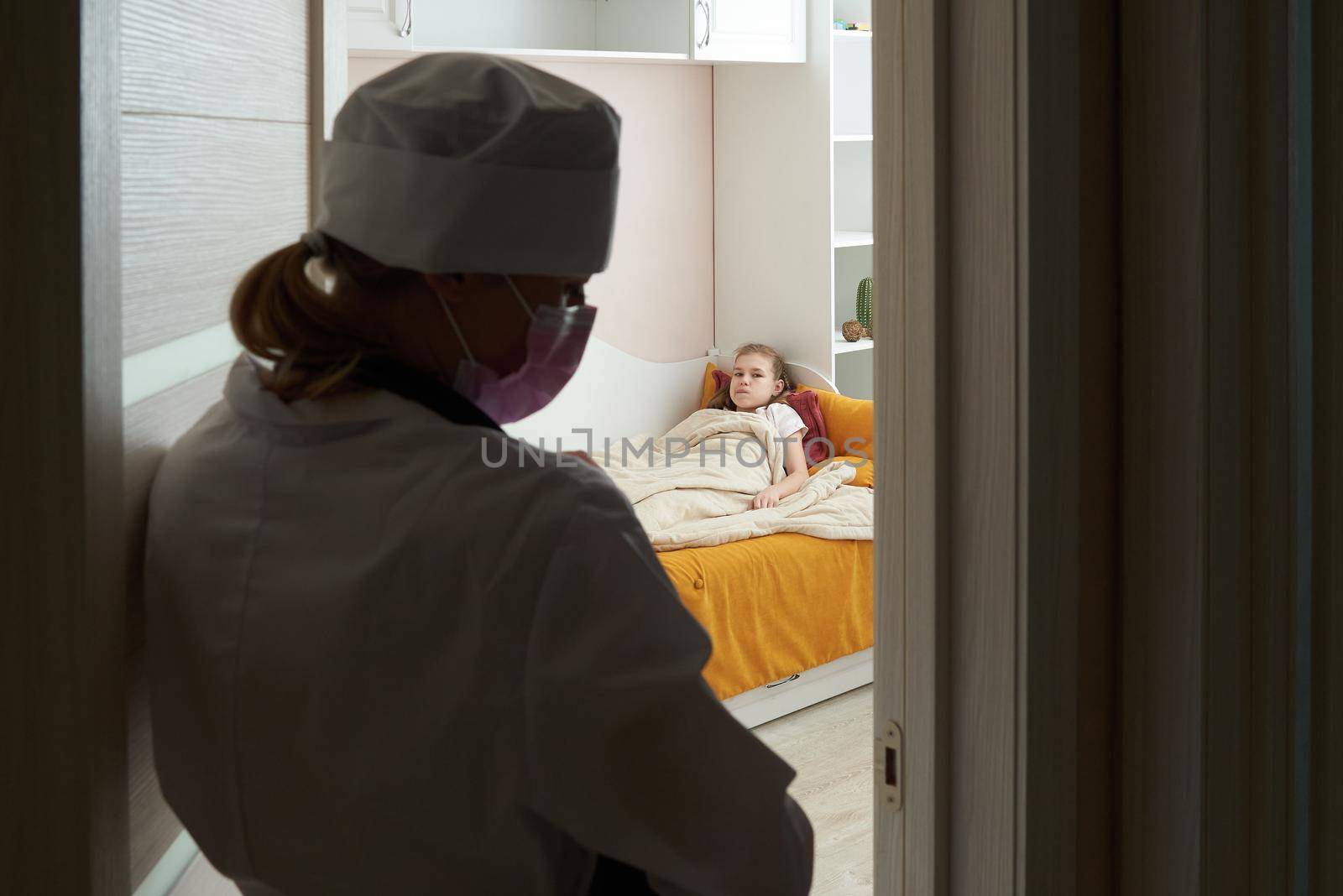 Doctor entering room visiting sick little girl at home, consulting patient