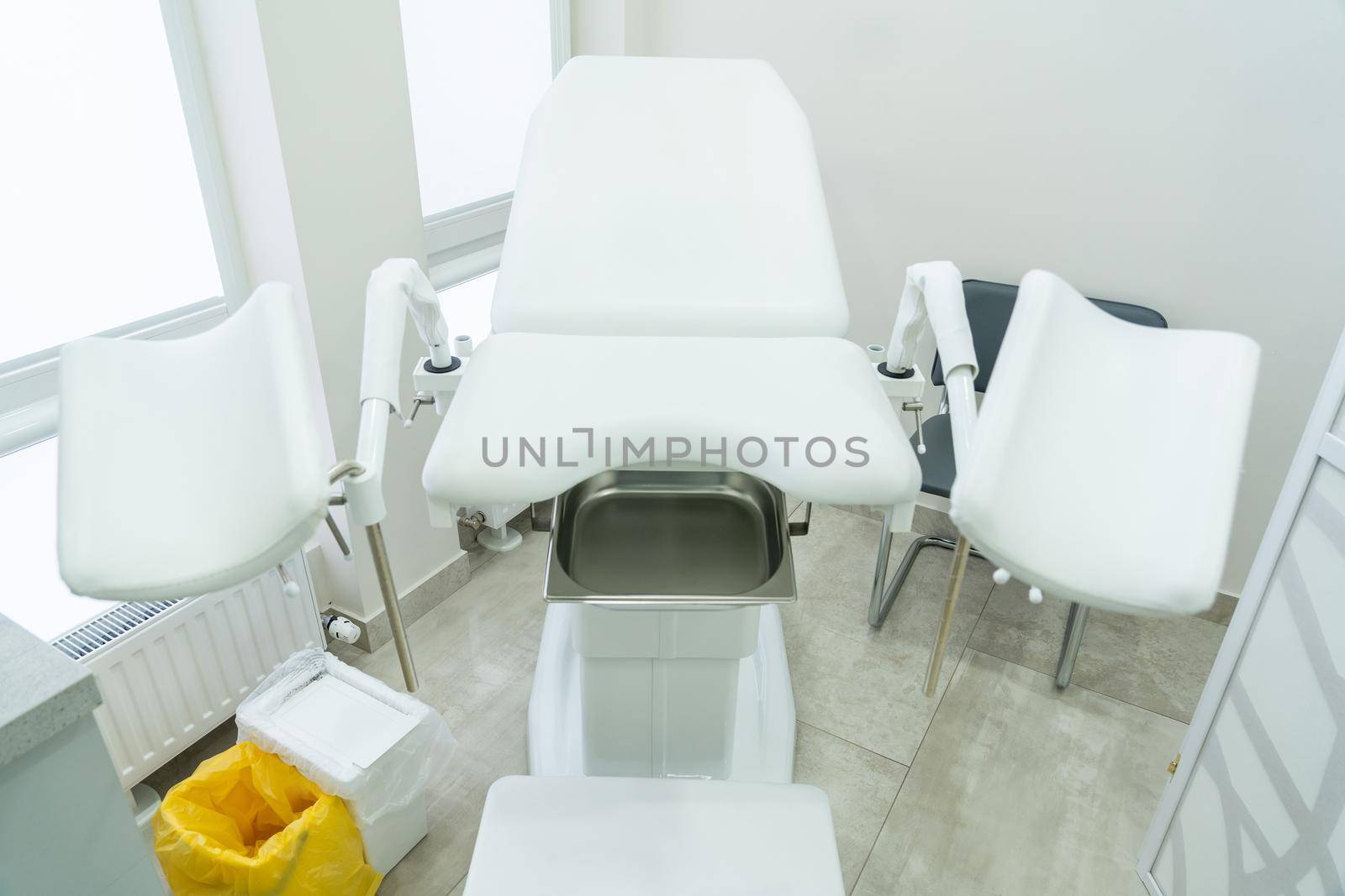 Empty white gynecological chair in a modern medical center