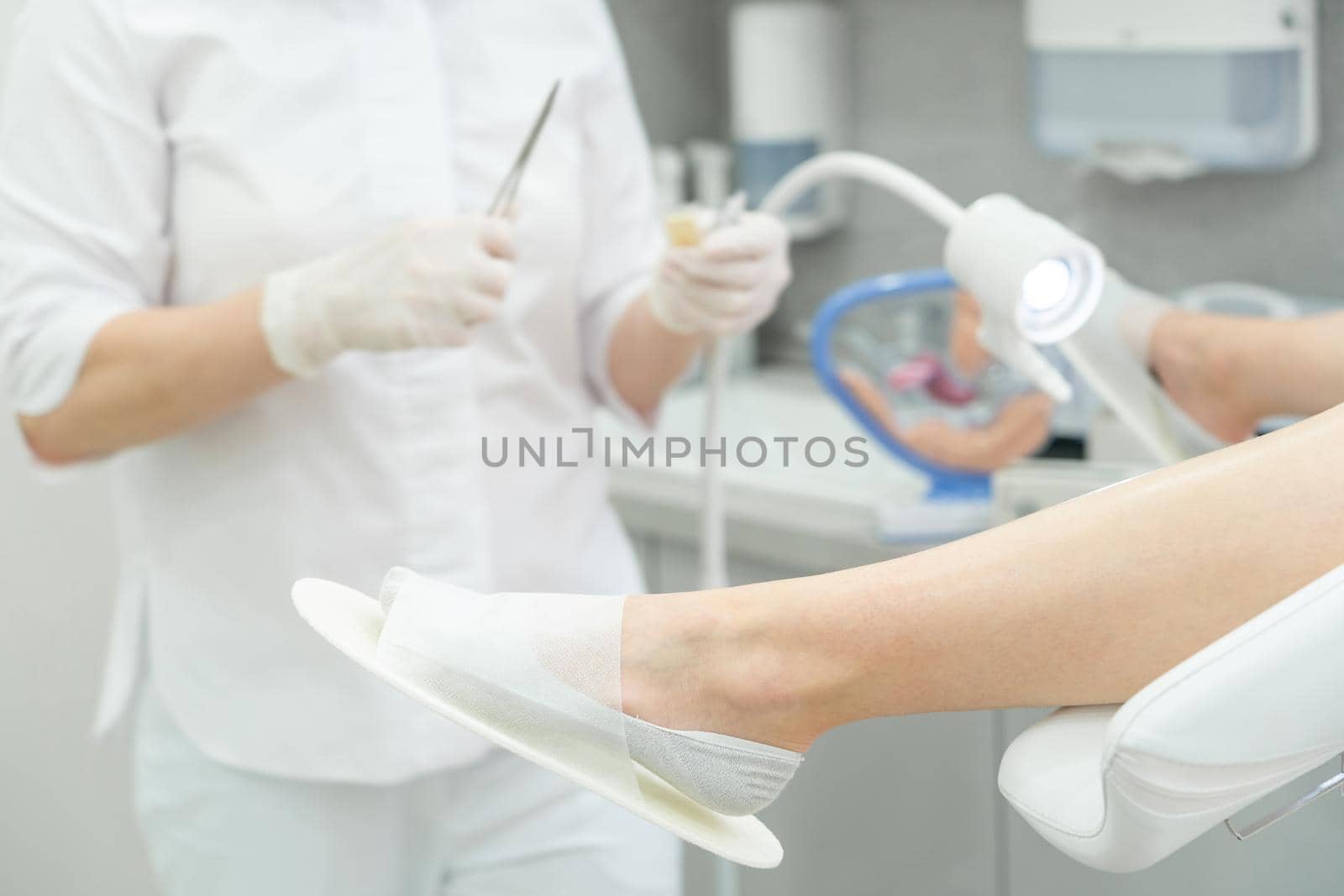 Gynecologist opening up band aid with forceps by Mariakray