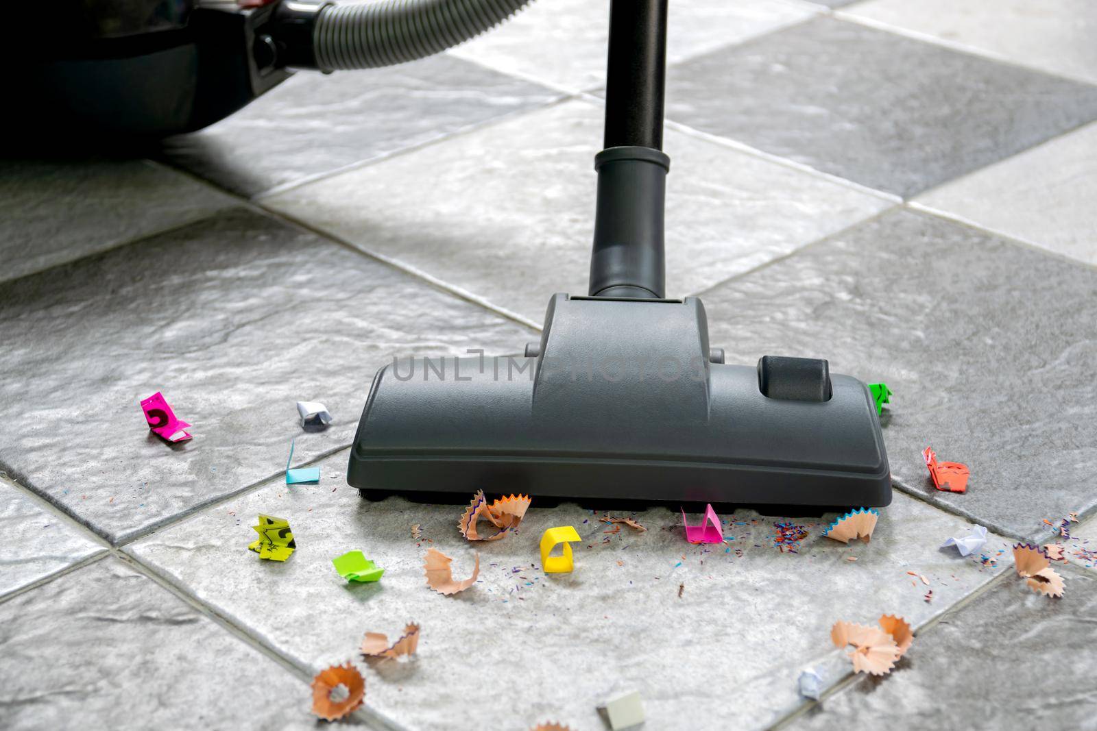 Sweep up paper scraps and dust on tile floors with a vacuum cleaner.