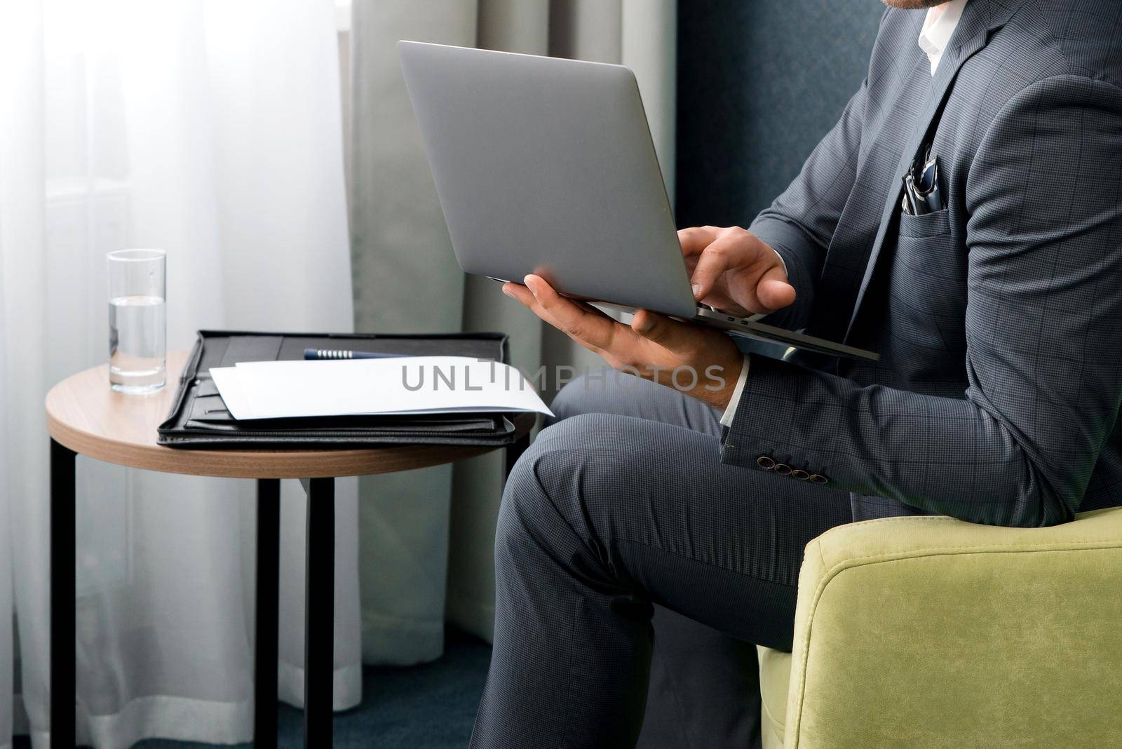 Young businessman working on laptop, sitting in hotel