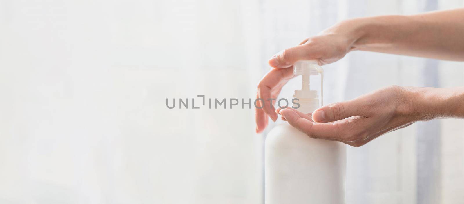 Woman hands pushing pump plastic soap bottle