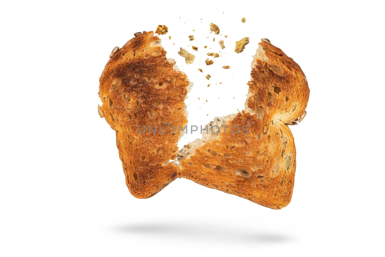 White bread slice isolate broken into 2 pieces with flying crumbs. Toaster fried bread isolated on white background. The concept of a small, dietary crispy breakfast