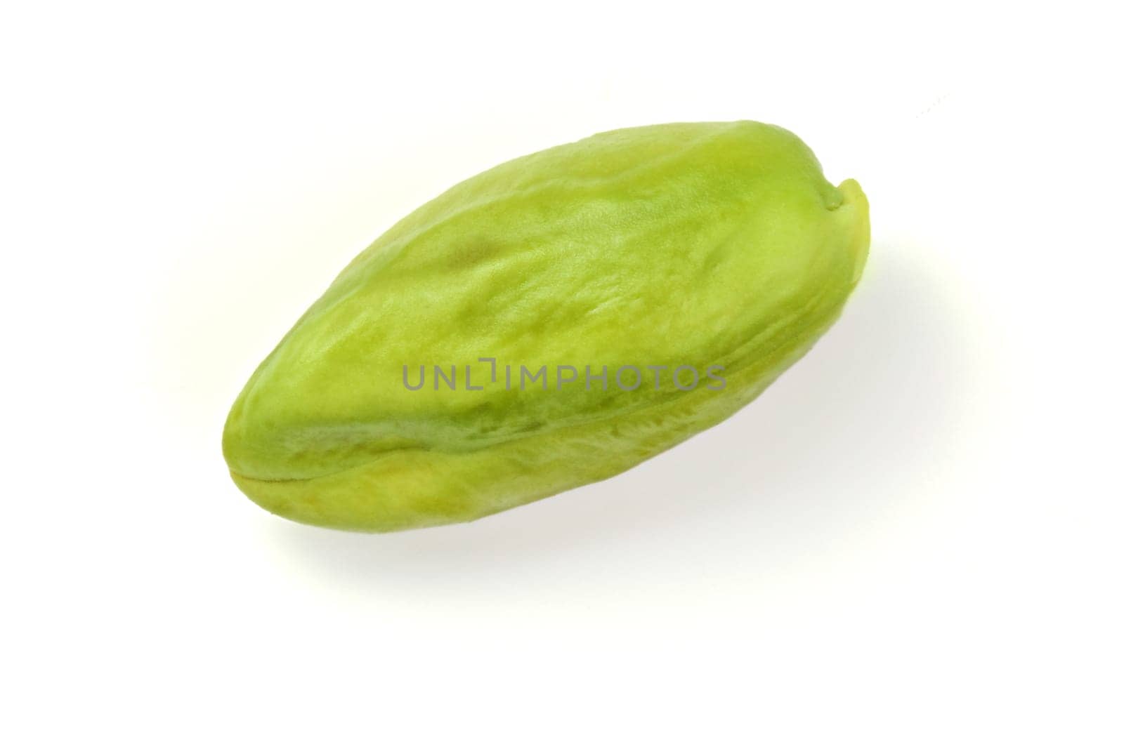 Single green peeled pistachio isolated on white background.