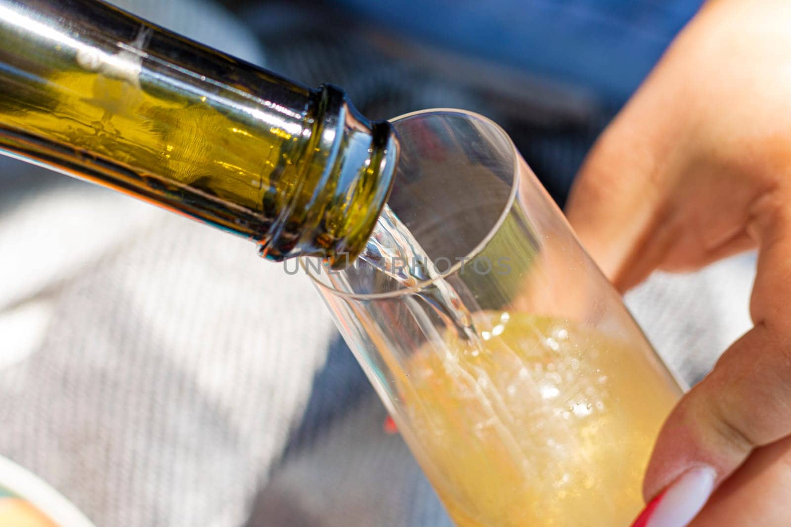 Wine. Glass of wine. Hands serving bottles of wine in transparent glasses . Toast. Celebration day. Photography. Hand pouring white wine in glass. Close up view.