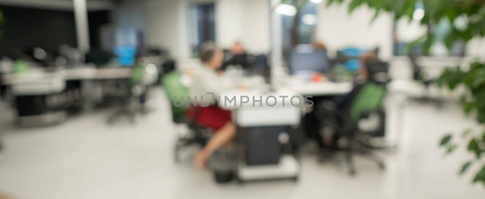 Blurry photo. Four colleagues at their desks